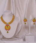 Elegant gold necklace and earrings set with emerald and ruby accents, perfect for traditional occasions.