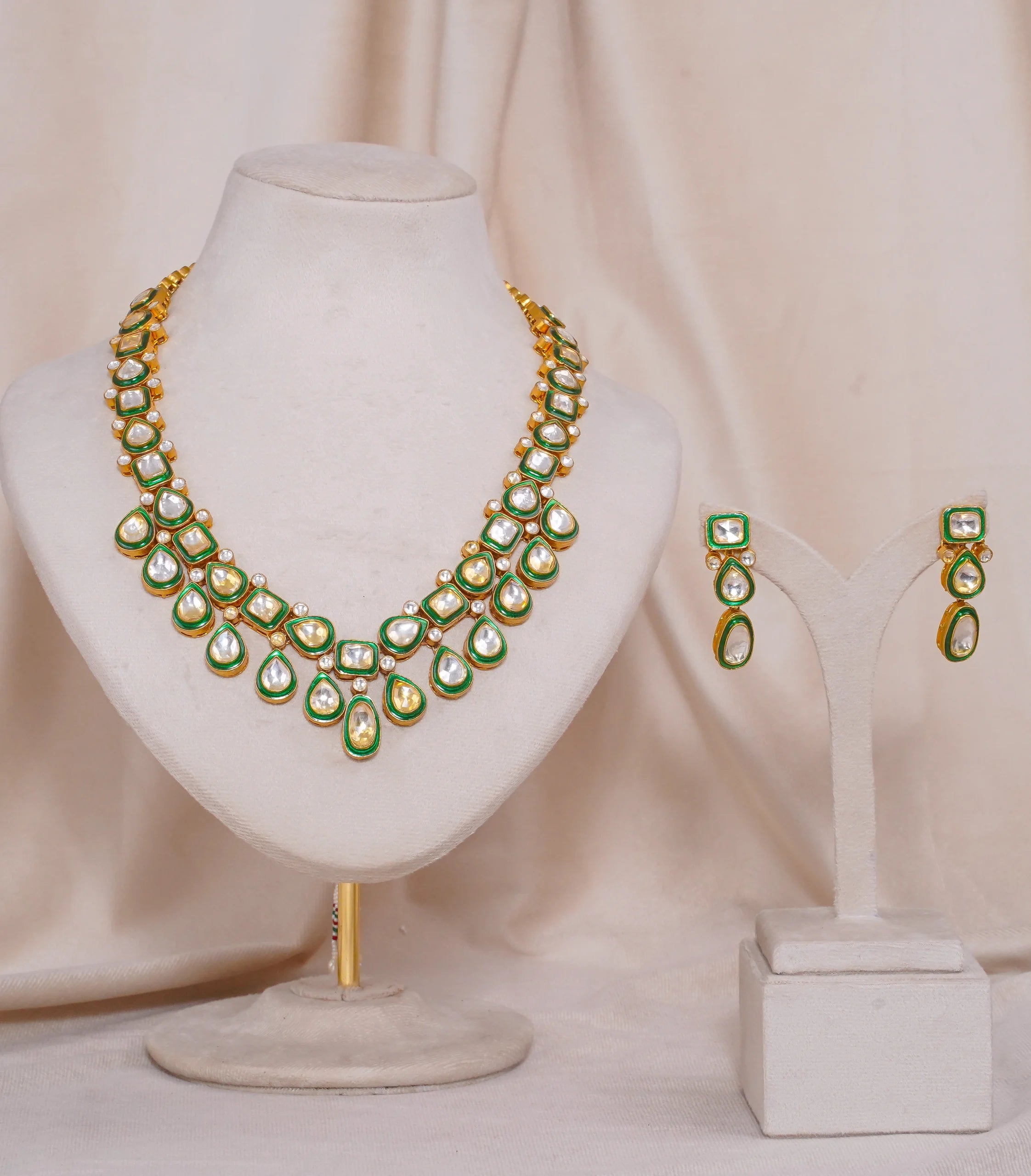 Elegant gold necklace and earrings set with green enamel and white stones, perfect for traditional occasions.