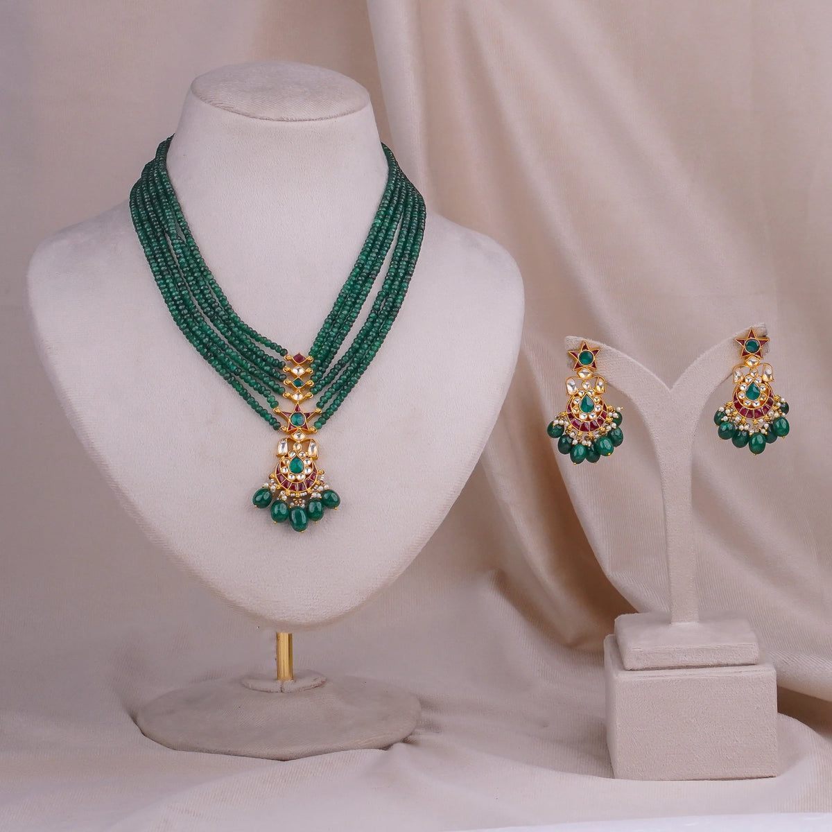 Emerald green beaded necklace set with gold pendant and matching jhumka earrings, traditional Indian jewelry