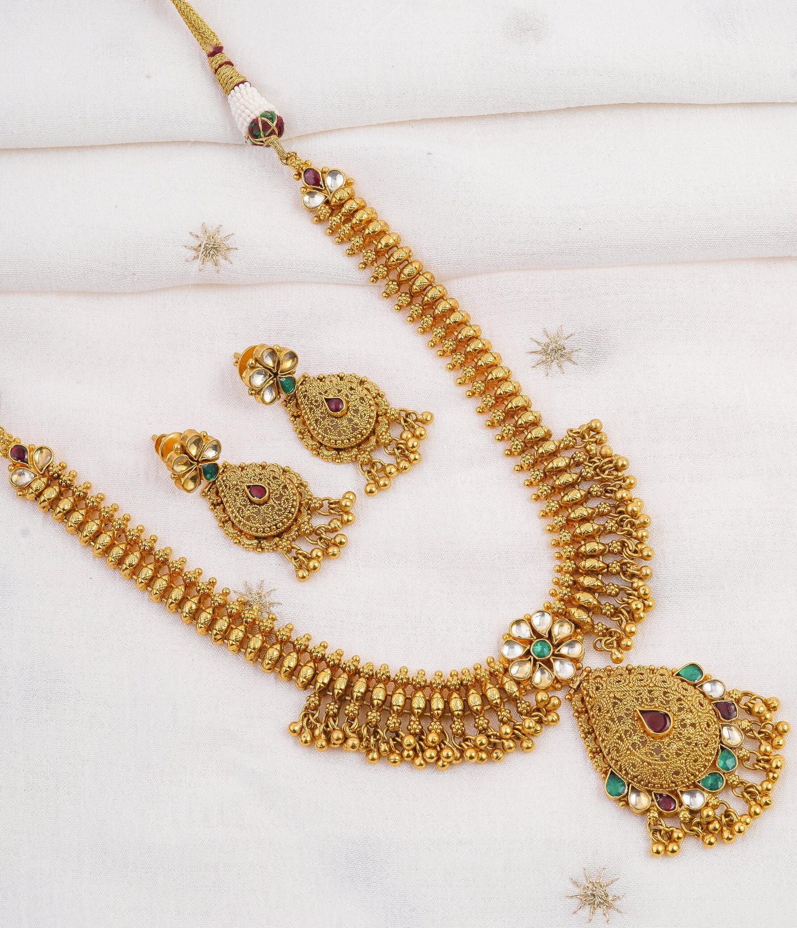 Elegant gold necklace set with intricate designs and colorful gemstones, perfect for traditional occasions.