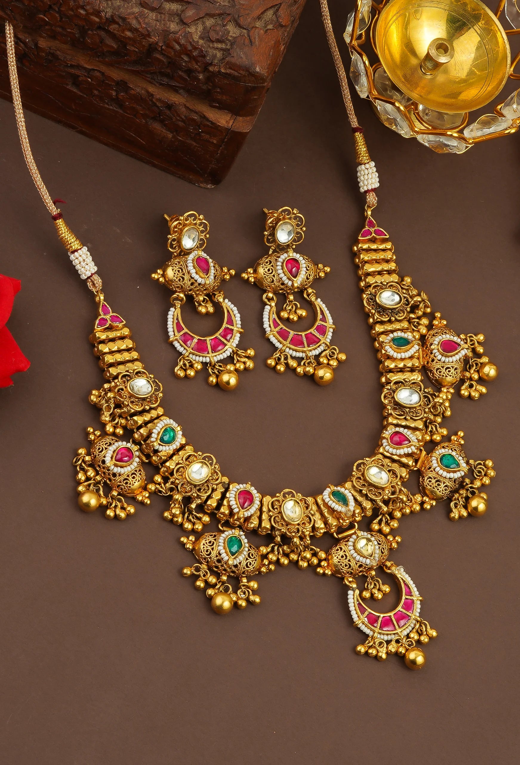 Elegant gold necklace and earrings set with pink and green gemstones, perfect for traditional occasions.