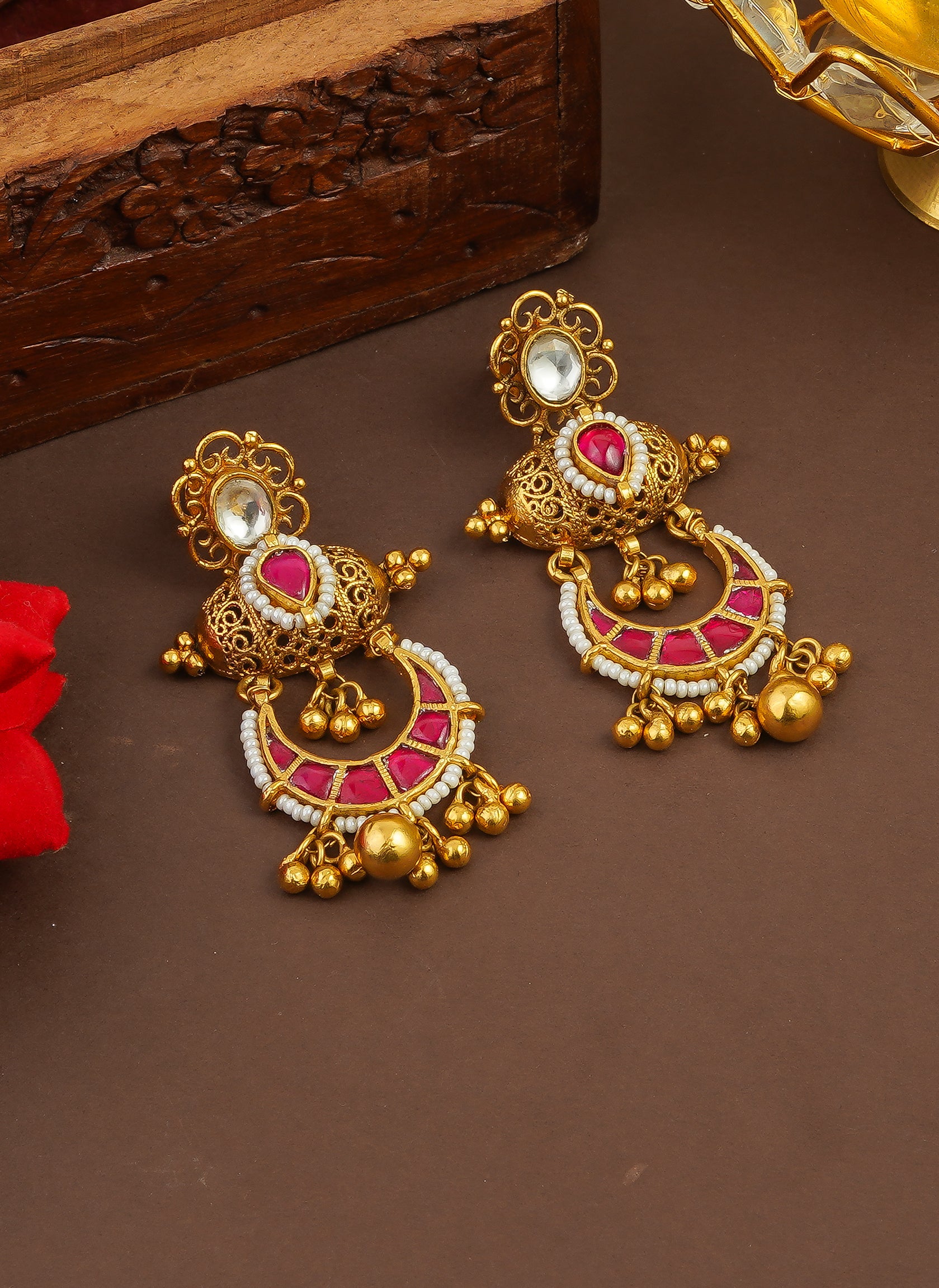 Gold jhumka earrings with pink stones and pearl detailing, traditional Indian jewelry design