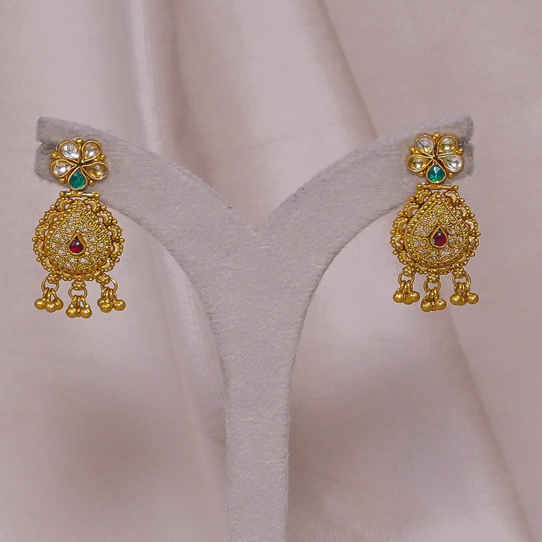Gold jhumka earrings with emerald and ruby accents, traditional Indian jewelry design