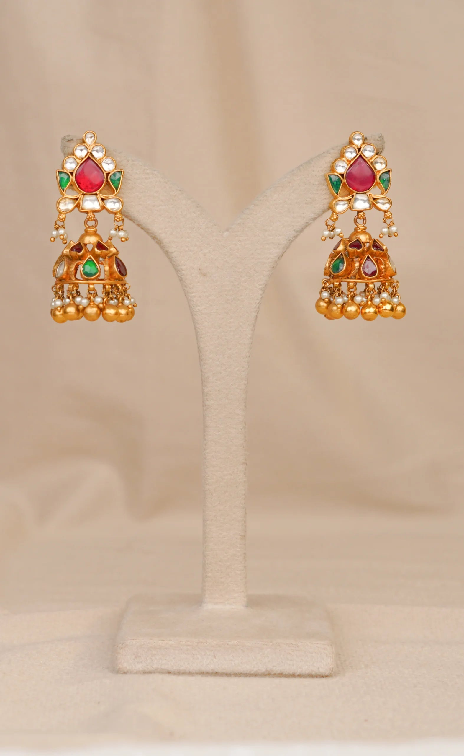 Gold jhumka earrings with red green stones and pearl drops, traditional Indian bridal jewelry