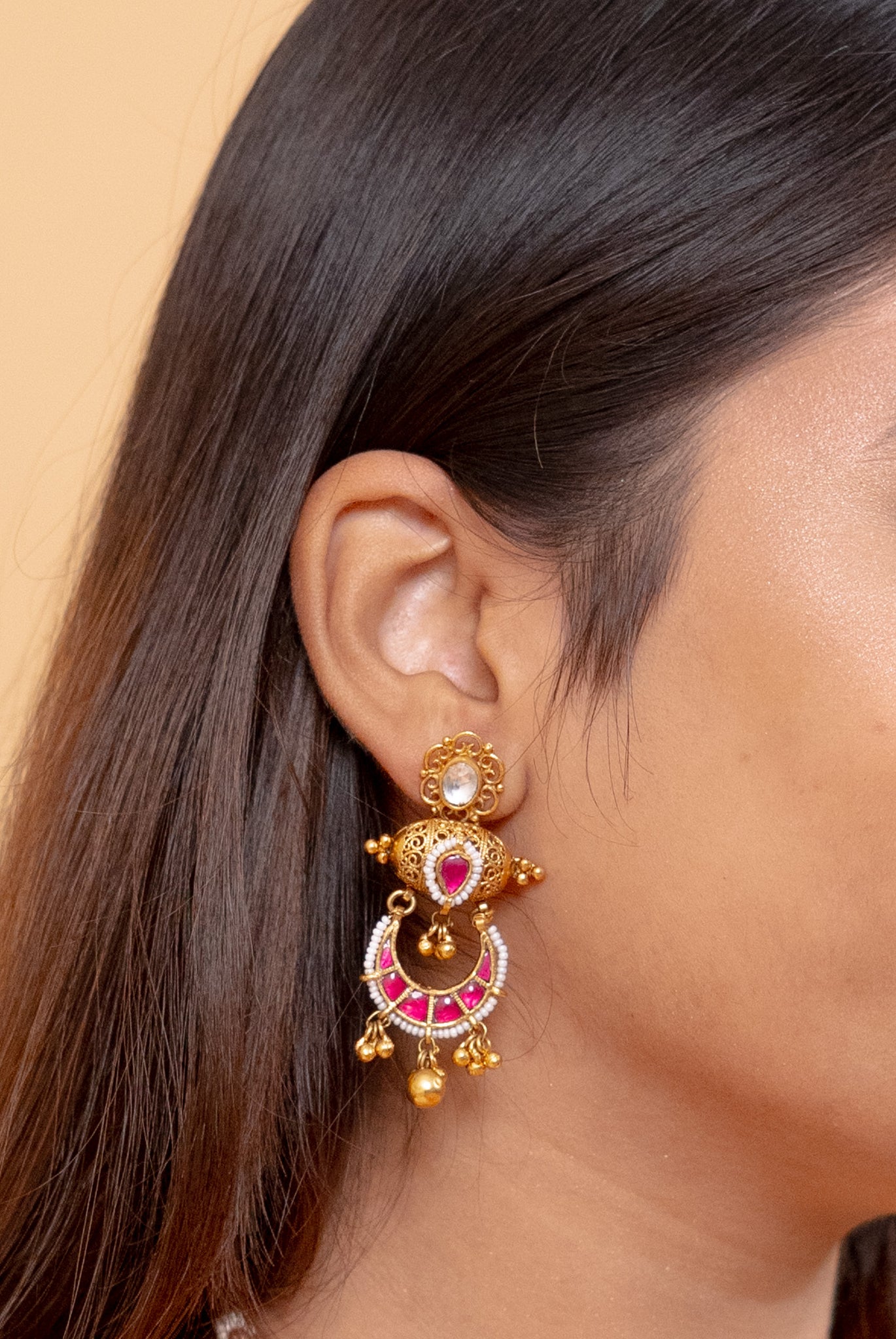 Elegant gold jhumka earrings with pink and white gemstones, perfect for traditional wear.